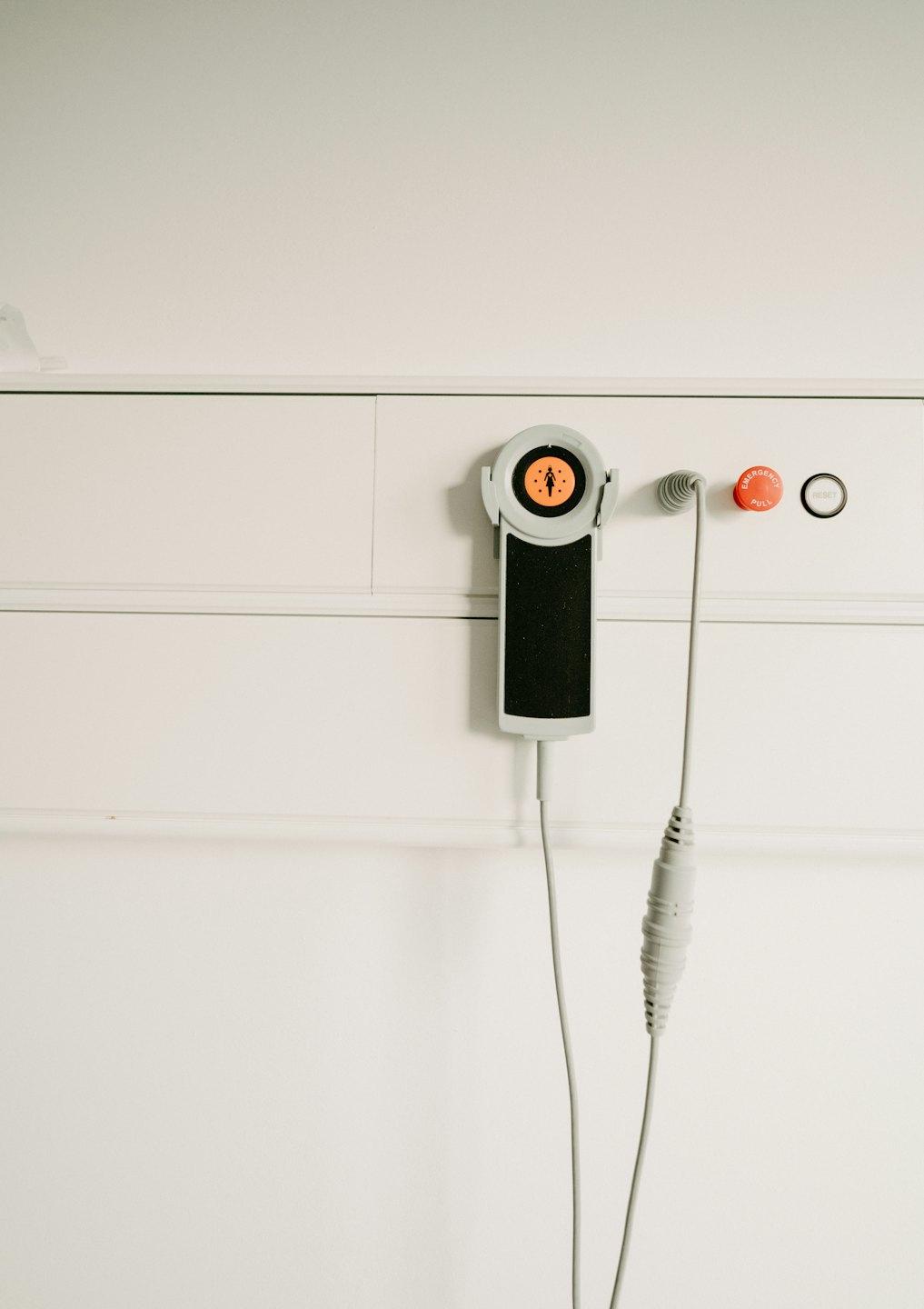 Hospital room call system with emergency pull button on wall.